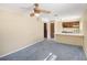 View of the living room opening to the kitchen with ceiling fan and neutral walls at 3752 Chattahoochee Dr, Douglasville, GA 30135