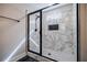 Elegant marble shower with a black framed glass door and a convenient built-in niche at 5328 Monticello Dr, Villa Rica, GA 30180