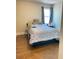A well-lit bedroom, with wood floors and a cozy bed with a patterned comforter at 526 Blue Mountain Rise, Canton, GA 30114