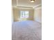 Primary bedroom showcases large sunny window, tray ceiling, and neutral carpeting at 526 Blue Mountain Rise, Canton, GA 30114