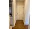 A hallway with hardwood flooring leading to the full bathroom, featuring a white door and baseboards at 526 Blue Mountain Rise, Canton, GA 30114
