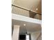 View of the living room and overhead landing featuring high ceilings, fan, and dark metal railing at 526 Blue Mountain Rise, Canton, GA 30114