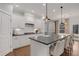 Elegant kitchen featuring white cabinets, granite countertops, an island with barstool seating, and stainless appliances at 6095 Marigold Way, Atlanta, GA 30349