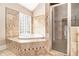 Bright bathroom features decorative tile work, garden tub, and separate glass enclosed shower at 1675 Dodson Sw Dr, Atlanta, GA 30311