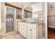 Bathroom featuring a double sink vanity, neutral stone tile, and glass door shower at 1675 Dodson Sw Dr, Atlanta, GA 30311