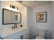 Bright bathroom boasts a modern vanity with black hardware, a framed mirror, and stylish light fixture at 493 Willow Springs Dr, Marietta, GA 30068