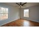 Bright bedroom featuring hardwood floors, neutral walls, modern ceiling fan, and large double-hung windows at 493 Willow Springs Dr, Marietta, GA 30068