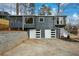 View of the home's rear exterior, featuring the 2-car garage, retaining wall, and neutral-toned siding at 493 Willow Springs Dr, Marietta, GA 30068