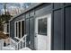 Contemporary gray home featuring a white-trimmed front door and windows, set in a wooded landscape at 493 Willow Springs Dr, Marietta, GA 30068