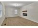 Spacious living room with wood-look floors, white walls, a modern fireplace, and ample natural light at 2328 Carnes Rd, Jonesboro, GA 30236