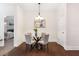 Dining room with hardwood floors, a modern light fixture, and views into the Primary bedroom at 250 High Court Way, Locust Grove, GA 30248