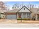 Charming single-Gathering home with a two-car garage, brick accents, a red front door, and manicured landscaping at 250 High Court Way, Locust Grove, GA 30248