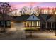 Charming single-story home with a stone facade, two-car garage, and welcoming front porch at dusk at 250 High Court Way, Locust Grove, GA 30248