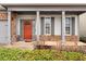 Inviting front porch with stone accents, a vibrant red front door and manicured landscaping at 250 High Court Way, Locust Grove, GA 30248