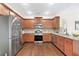 Modern kitchen boasts stainless steel appliances, granite countertops and wooden cabinets at 250 High Court Way, Locust Grove, GA 30248