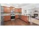Well-equipped kitchen features stainless steel appliances, granite countertops, and hardwood floors open to the living room at 250 High Court Way, Locust Grove, GA 30248