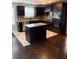 Modern kitchen with dark cabinetry, stainless steel appliances, and a center island at 215 Bradley St, Covington, GA 30016