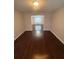 Spacious living room with hardwood floors, neutral walls, and an open doorway at 215 Bradley St, Covington, GA 30016
