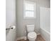 Clean and simple bathroom featuring a standard toilet, window, and a combined bathtub and shower at 615 Ceremony Way, Acworth, GA 30102