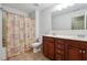 Bright bathroom features double vanity with dark cabinets and tub-shower with decorative curtain at 615 Ceremony Way, Acworth, GA 30102