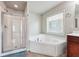 Bright bathroom featuring a glass shower and a corner tub, providing a spa-like experience at 615 Ceremony Way, Acworth, GA 30102