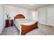 Well-lit bedroom featuring a dark wooden bed frame, carpet, and bedside table, perfect for relaxation at 615 Ceremony Way, Acworth, GA 30102