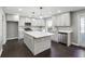 Well-lit kitchen featuring an island, dark hardwood floors, stainless steel appliances, and white cabinets at 615 Ceremony Way, Acworth, GA 30102