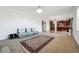 Open-concept living room with view to the kitchen featuring comfortable seating and neutral carpet at 615 Ceremony Way, Acworth, GA 30102