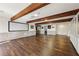 Finished basement featuring exposed wood beams, hardwood flooring, and a large projector screen at 320 Spyglass Blf, Alpharetta, GA 30022