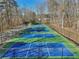 View of a community amenity including six fenced pickleball courts with green and blue playing surfaces at 320 Spyglass Blf, Alpharetta, GA 30022