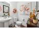 Neat powder room decorated with pretty floral artwork and fresh flowers at 236 Augusta Walk, Canton, GA 30114