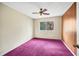 Bedroom with wood paneling, ceiling fan, window and purple carpet at 2570 Bradford Ne Sq, Atlanta, GA 30345