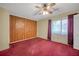 Bedroom with wood paneling, ceiling fan, window and red carpet at 2570 Bradford Ne Sq, Atlanta, GA 30345