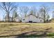 Expansive backyard with lush green grass, mature trees, and a charming home in the background at 915 Homer Rd, Woodstock, GA 30188