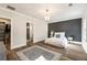 Stylish main bedroom featuring hardwood floors, an accent wall, and an attached bathroom at 915 Homer Rd, Woodstock, GA 30188