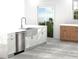 Bright kitchen featuring white cabinets, a stainless steel dishwasher, a farmhouse sink, and modern lighting at 2585 Governors Walk Blvd, Snellville, GA 30078