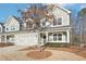 Lovely townhouse featuring a spacious two-car garage, a well-kept lawn, and a cozy front porch for relaxation at 334 Cherokee Station Cir, Woodstock, GA 30188