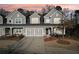 Charming townhouse with a two-car garage, neutral gray siding, and well-maintained landscaping at sunset at 334 Cherokee Station Cir, Woodstock, GA 30188