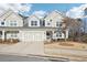 Charming townhome featuring a two-car garage, neutral siding, and a well-manicured front lawn at 334 Cherokee Station Cir, Woodstock, GA 30188