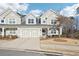 Charming townhouse exterior with a two-car garage, manicured lawn, and inviting front porch at 334 Cherokee Station Cir, Woodstock, GA 30188