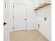 Well-lit laundry room with neutral walls, tile flooring, and overhead cabinets at 334 Cherokee Station Cir, Woodstock, GA 30188