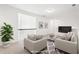 Bright, staged living room featuring two armchairs, area rug, and mounted television at 334 Cherokee Station Cir, Woodstock, GA 30188