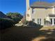 View of the home's rear exterior, with the lush greenery and patio seating at 3381 Walkers Ridge Rd, Dacula, GA 30019