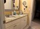Bathroom vanity featuring dual sinks, granite countertop, and decorative mirror with bright lighting at 3381 Walkers Ridge Rd, Dacula, GA 30019