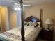 Bedroom featuring four poster bed, bedside table with lamp, and neutral color scheme at 3381 Walkers Ridge Rd, Dacula, GA 30019
