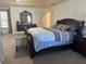 Spacious bedroom featuring neutral carpet, large bed, side tables, dresser, and chair with window at 3381 Walkers Ridge Rd, Dacula, GA 30019