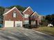 Elegant two-story brick home featuring a two-car garage, mature landscaping, and a well-maintained lawn at 3381 Walkers Ridge Rd, Dacula, GA 30019