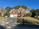 Charming two-story red brick home featuring a well-maintained front yard and a two-car garage at 3381 Walkers Ridge Rd, Dacula, GA 30019