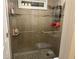 Modern glass shower with tiled walls, shower caddy, and updated shower head fixture at 3381 Walkers Ridge Rd, Dacula, GA 30019