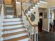 Elegant staircase with wood steps, white railings, and decorative wall art at 3381 Walkers Ridge Rd, Dacula, GA 30019